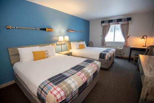 a hotel room with two beds and a desk at Mountain Inn at Lutsen in Lutsen