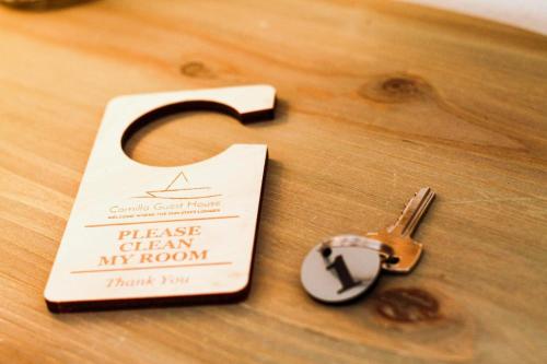 a wooden table with a key and a piece of paper at Guest House Camilla in Alghero