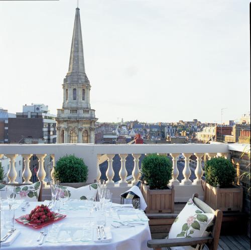 a table on a balcony with a view of the city at The Mandeville Hotel in London