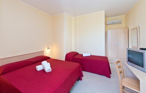 a hotel room with two beds and a flat screen tv at Otus Camere in Otranto