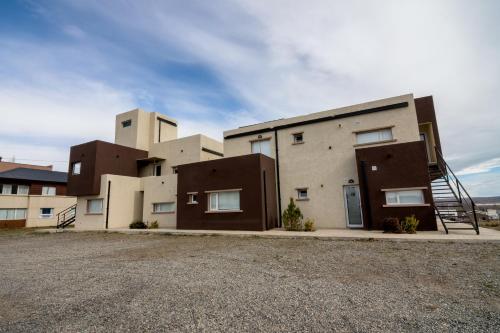 a building with a staircase in front of it at Tierra Tehuelche Hostería y Aparts in El Calafate