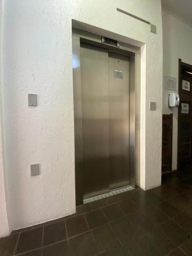 a elevator door in a room with a brick wall at Hotel Somensi in Bento Gonçalves