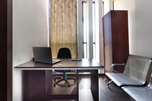 an office with a desk with a laptop and chairs at Hotel Alpine Glow Heights in Trimulgherry