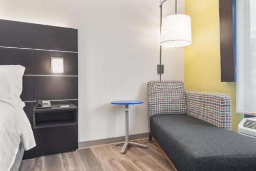 a room with a bed and a chair and a table at Holiday Inn Express & Suites - Hardeeville-Hilton Head by IHG in Hardeeville