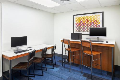 a room with a desk with two monitors and chairs at Holiday Inn Express & Suites - Spartanburg-North by IHG in Spartanburg