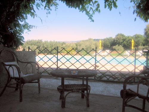 a table and chairs with a view of a river at Agriturismo Bio Pian Dei Casali in Saturnia