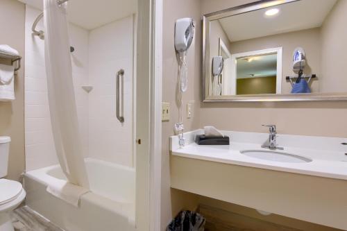 a bathroom with a sink and a toilet and a mirror at Knight's Inn Boston/Danvers in Danvers