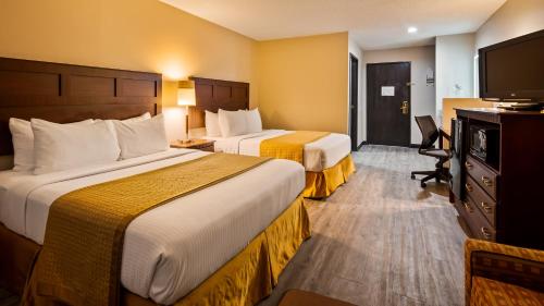 a hotel room with two beds and a flat screen tv at SureStay Hotel by Best Western Orange in Orange