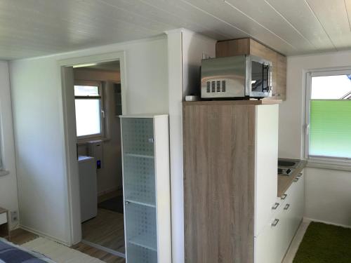 a kitchen with a microwave on top of a cabinet at Ferienbungalow Grünbach in Grünbach