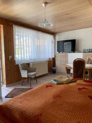 a bedroom with a bed and a desk and a kitchen at Landgasthaus & Pension Liebner-Land Brandenburg-Prignitz in Groß Pankow