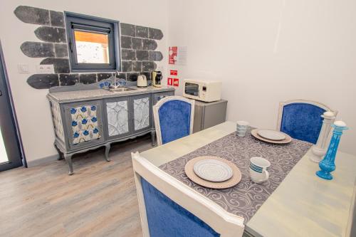 uma sala de jantar com uma mesa e cadeiras azuis em Casa do Leão em Marialva