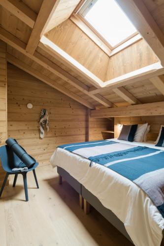une chambre avec un lit et une lucarne dans l'établissement Coco Chalet, à Arâches-la-Frasse