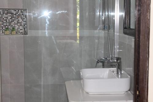 a bathroom with a white sink and a mirror at Sand and Blue Seas in Negril