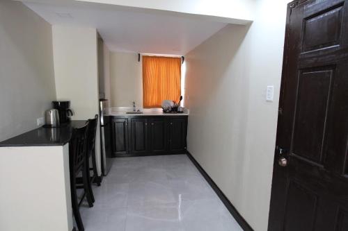 a room with a kitchen with a sink and a window at Sand and Blue Seas in Negril