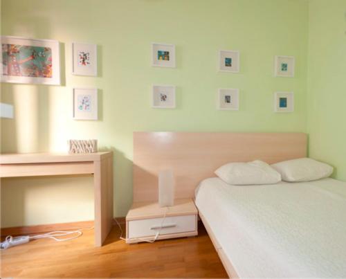 1 dormitorio con cama, escritorio y cuadros en la pared en Zen Central Apartment, en Lisboa