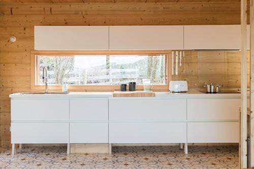 a kitchen with white cabinets and a window at Coco Chalet in Arâches-la-Frasse