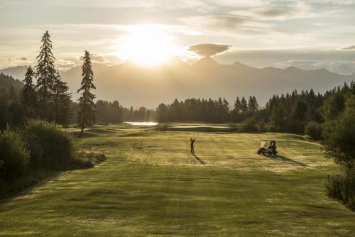 a view of a golf course with the sun in the background at St. Eugene Golf Resort & Casino in Cranbrook