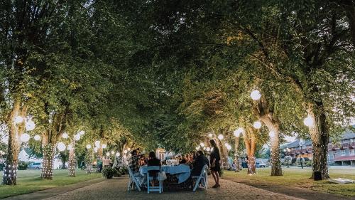 a group of people sitting at tables under trees at St. Eugene Golf Resort & Casino in Cranbrook