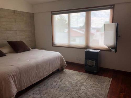 een slaapkamer met een bed en een groot raam bij Habitaciones con baño privado disponibles in Mexico-Stad