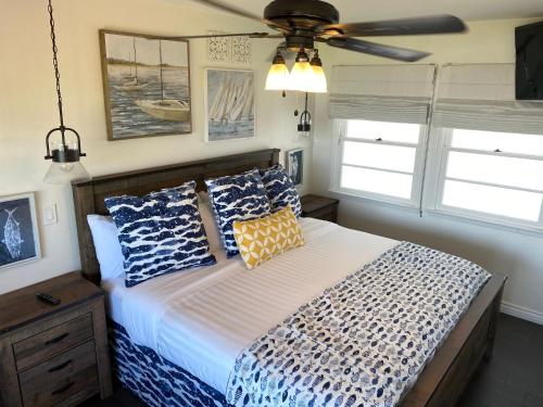 a bedroom with a bed with pillows and a ceiling fan at Beachcomber Inn in San Clemente