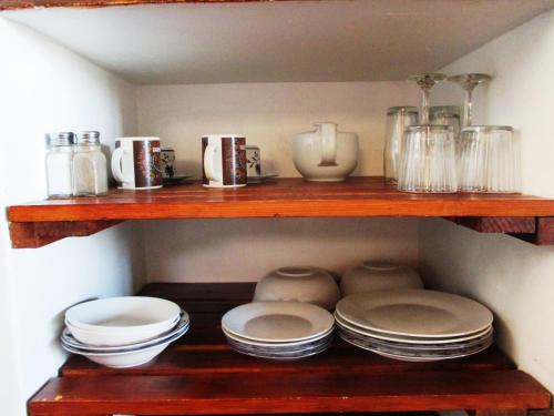 a wooden shelf with plates and dishes on it at The Overlook in Keimoes