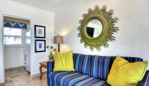 a living room with a blue and yellow couch and a mirror at Beachcomber Inn in San Clemente