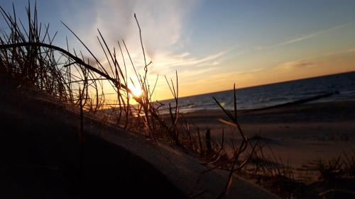 a sunset on a beach with the ocean at Azalia 32 Mielno l in Mielno