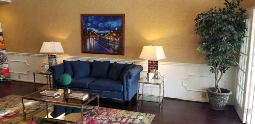 a living room with a blue couch and a plant at Quality Inn in Bainbridge