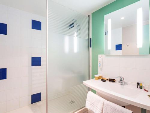 uma casa de banho com um chuveiro e um lavatório. em ibis budget Angoulême Nord em Champniers