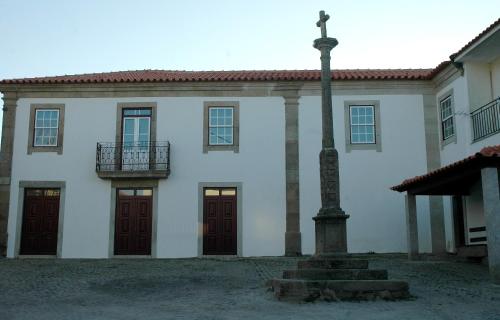 a white building with a cross in front of it at Casa Dos Lagares De Vara E Pedra in Vila Flor