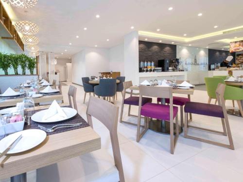a dining room with tables and chairs in a restaurant at ibis Styles Manama Diplomatic Area in Manama