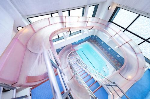 an overhead view of an indoor swimming pool with a spiral staircase at Hotel Regent (Adult Only) in Nagoya
