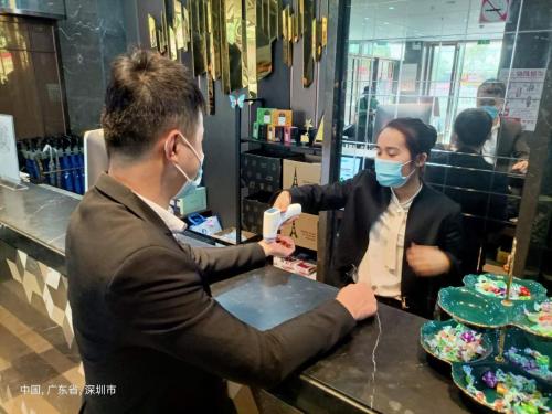 a man and a woman wearing face masks in a bakery at lnsail Hotel Shenzhen Luohu Port Railway Station in Shenzhen