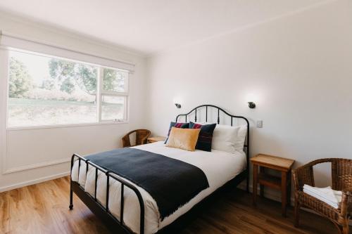 a bedroom with a black and white bed and a window at The Robin Hood Inn in Drouin West