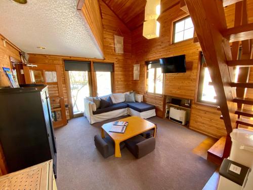 a living room with a couch and a table at ZEN CHALETS Hakuba in Hakuba