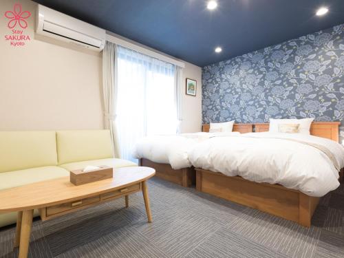 a hotel room with two beds and a couch at Stay SAKURA Kyoto Nijo Seasons in Kyoto