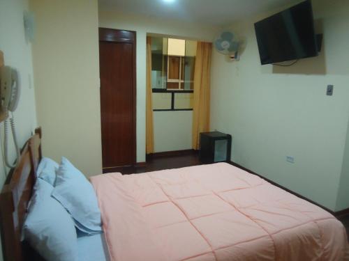 a bedroom with a bed and a television in it at Hotel Panamericano in Lima