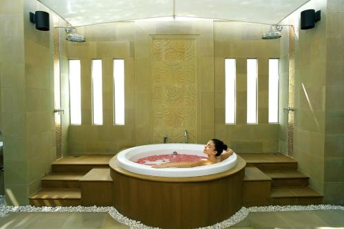 a woman is sitting in a bath tub at Dusit Thani Pattaya - SHA Extra Plus in North Pattaya
