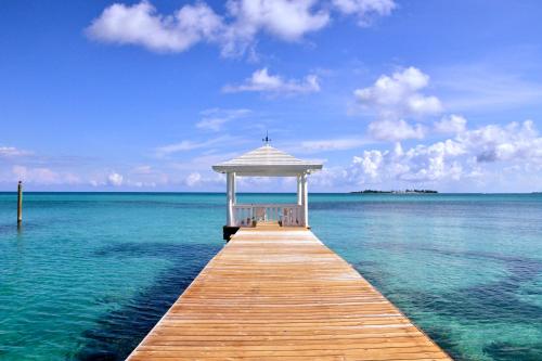 a wooden pier with a gazebo on the water at Sandyport Beach Resort in Nassau