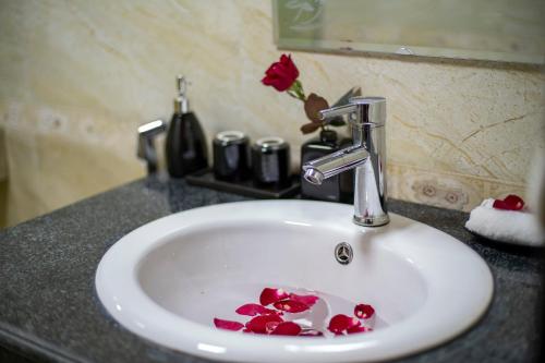 a bathroom sink with red roses on it at Sapphire Sapa Hotel in Sapa