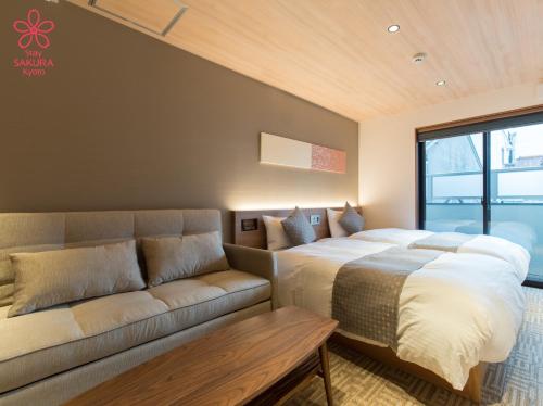 um quarto com uma cama e um sofá em Stay SAKURA Kyoto Higashi Hongan-ji I em Quioto