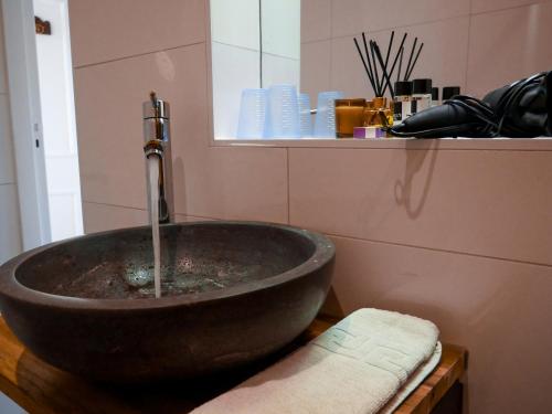 a bathroom with a bowl sink with a faucet at Hotel / Pension Villa Tanahlot in Zandvoort