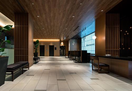 a lobby with chairs and a bar in a building at Daiwa Roynet Hotel Hakata Reisen PREMIER in Fukuoka