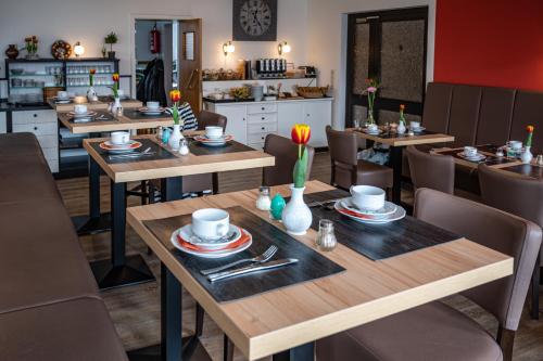 a dining room with wooden tables and chairs at Schlei Hotel in Kappeln