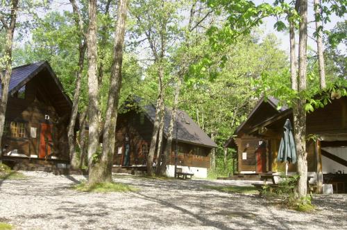 a couple of wooden cabins in the woods at Hakuba Brownie Cottages in Hakuba