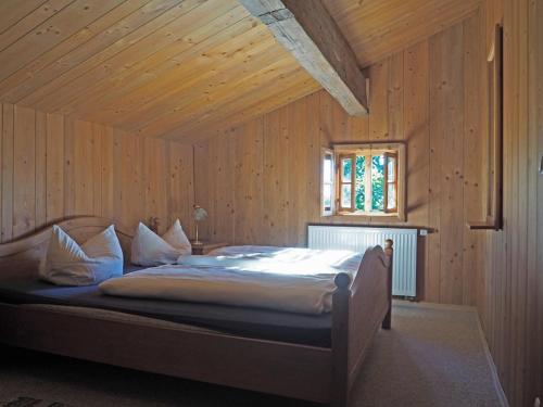 a bedroom with a bed in a wooden room at Das Waldlerhaus in Lam