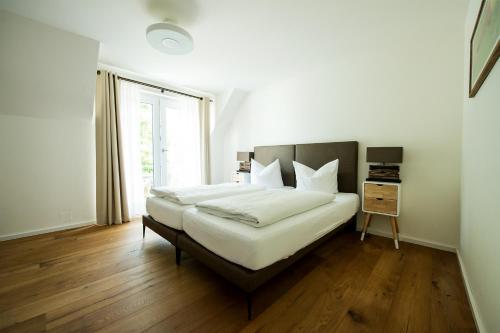 a bedroom with a bed with white sheets and a window at City Center Apartments in Kirchheim unter Teck