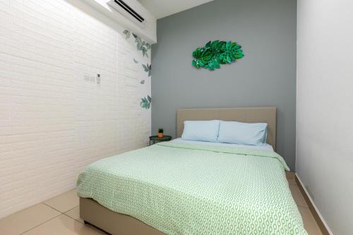 a bedroom with a bed with a green blanket at The Tropic@Midhill Genting (Free Wi-Fi) in Genting Highlands