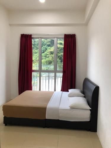 a bedroom with a bed with red curtains and a window at Golden Hill 3 Room Apt @ Night Market in Cameron Highlands