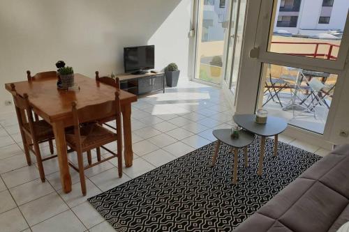 uma sala de estar com uma mesa e um sofá em Appartement plage de Trestraou em Perros-Guirec